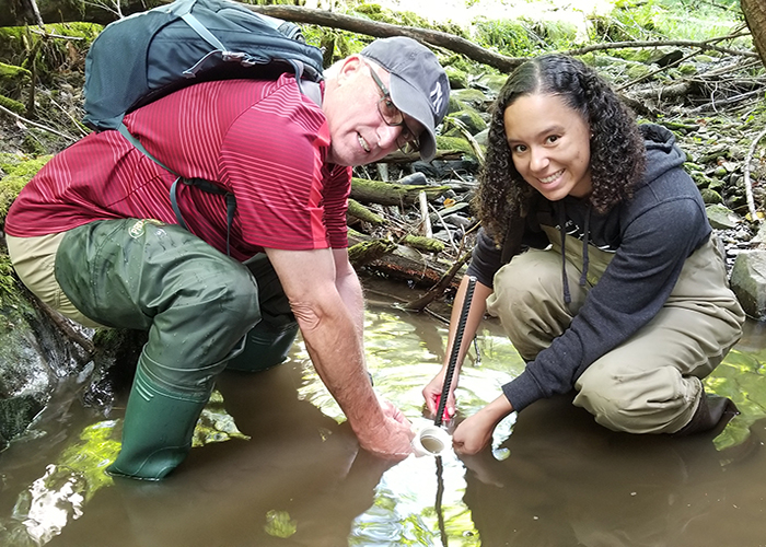 Ashley Donahue (right) and professor (left) working in a river on a drainage science project.