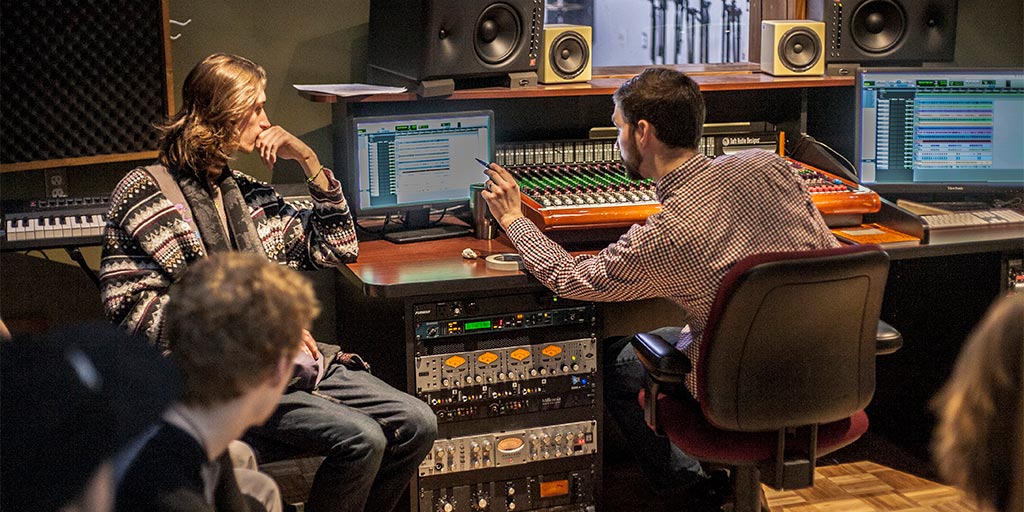 Students learn how to use the sound board as part of the Music Business program