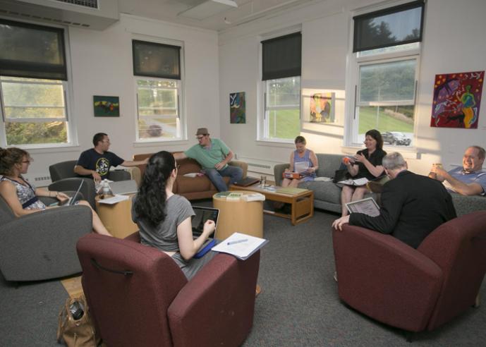 A group of students sitting and talking in a room.