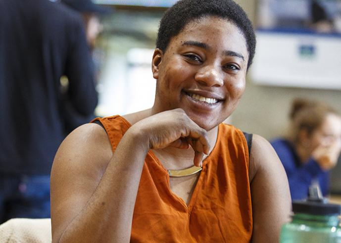 A woman with short, black hair, smiling, looking at camera.