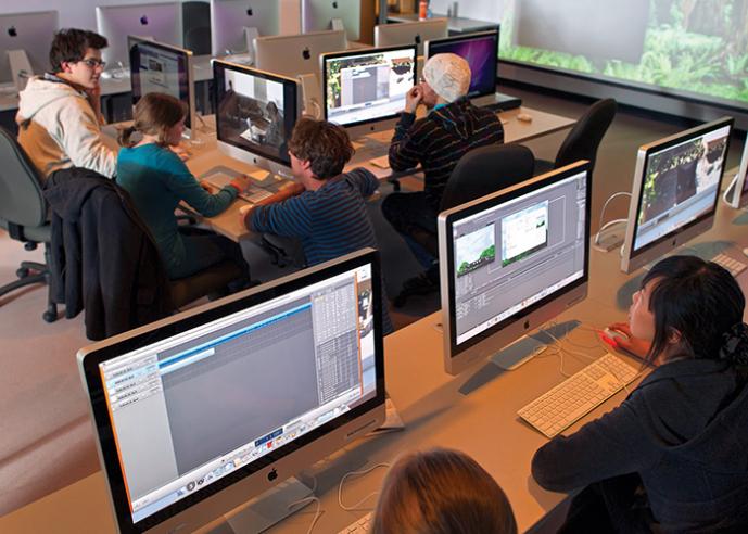 Students in a computer lab, working at desks and sitting in chairs.