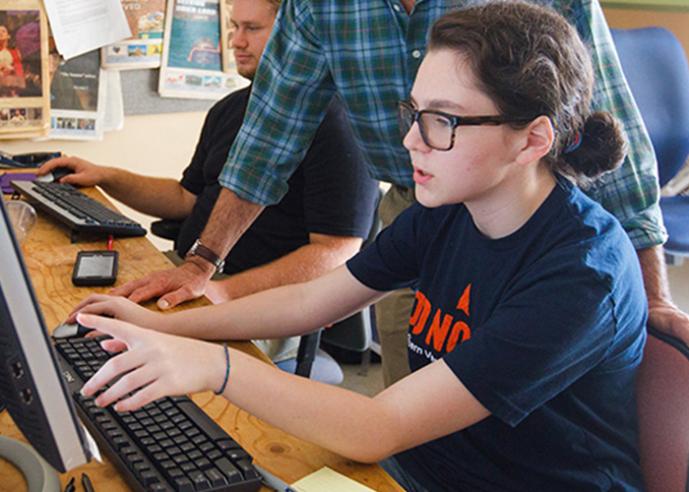 Students work on computers in a class.