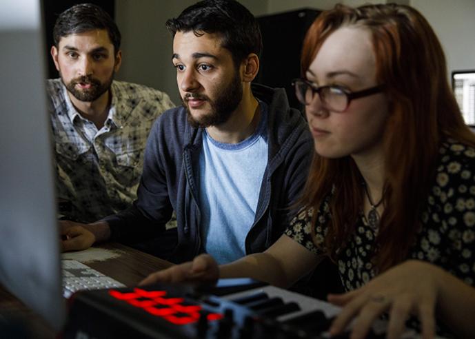 Three students work together in a computer lab.